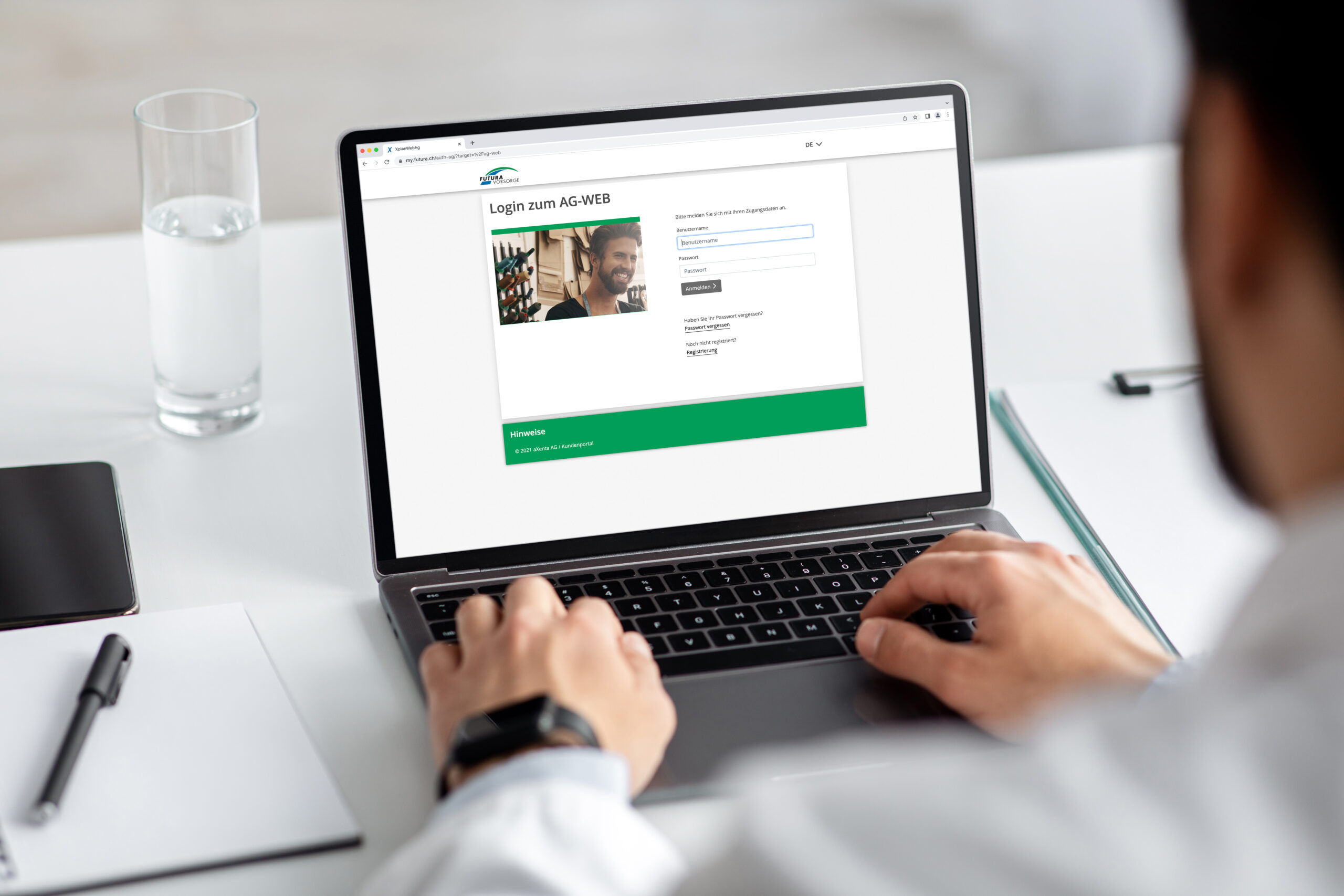 millennial-doctor-or-businessman-in-coat-works-on-laptop-with-empty-screen-for-text-on-white-desk